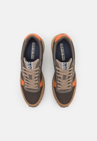 Sneakers marroni e beige con accenti arancioni. Parte superiore in tessuto, punta rotonda, chiusura con lacci e suola in gomma con un motivo testurizzato.