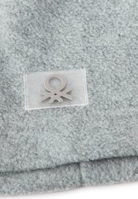 Tissu en feutre gris clair avec une surface douce et texturée, présentant une pièce transparente avec un design de logo gris.