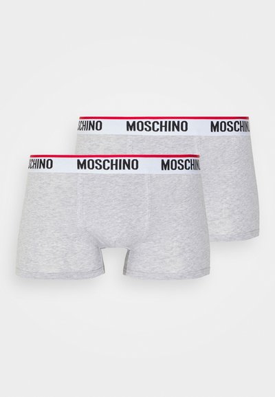 Pelēki kokvilnas džinsi ar melnu un sarkanu Moschino logotipa jostu. Mīksta tekstūra ar pieguļošu dizainu, parādot divas pāriem viens virs otra.