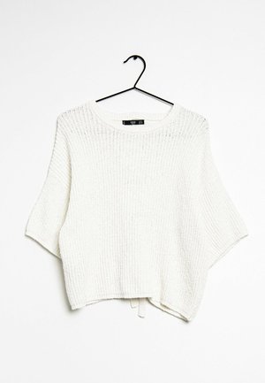 Hvid strikket kortærmet sweater med rund hals, hængende på en sort bøjle mod en hvid baggrund.
