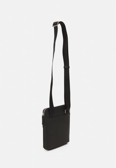 Black shoulder bag with a rectangular shape, made of smooth material. Features a zip closure and an adjustable strap with logo detailing.