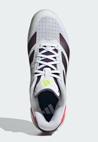 Baskets blanches avec des rayures sombres, lacets blancs, logo vert clair sur la languette et accent rouge au talon, vues de dessus.