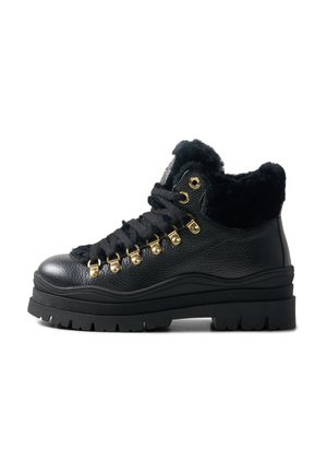 Schwarzer Leder-Stiefel mit dicker Sohle, goldenen Ösen, schwarzen Schnürsenkeln und weichem schwarzem Pelzfutter am Kragen.