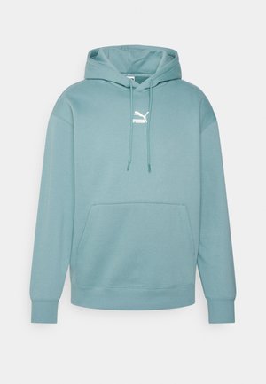 Vaaleanmerensininen Puma-huppari, jossa on etuosaaan kengurutasku, säädettävä huppu ja pieni valkoinen Puma-logo rinnan keskellä.