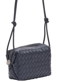 Borsa a tracolla intrecciata in pelle blu scuro con forma rettangolare, chiusura con zip, tracolla singola e accento metallico circolare.