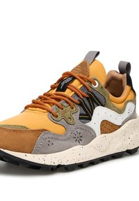 Multibarevná sportovní obuv skládající se z oranžové, hnědé a šedé semišové kůže s skvrnitou bílou gumovou podrážkou, doplněná černými a zelenými detaily.