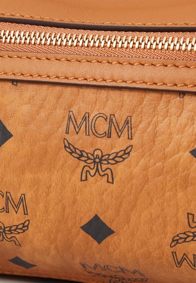 Brun läderväska med präglad MCM-logotyp och diamantmönster, gulddragkedja och texturerad yta.
