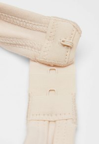 Béžový látkový pásek s dvěma nastavitelnými háčky, s texturovaným prošíváním a třemi řadami smyčkových uzávěrů pro bezpečné uchycení.