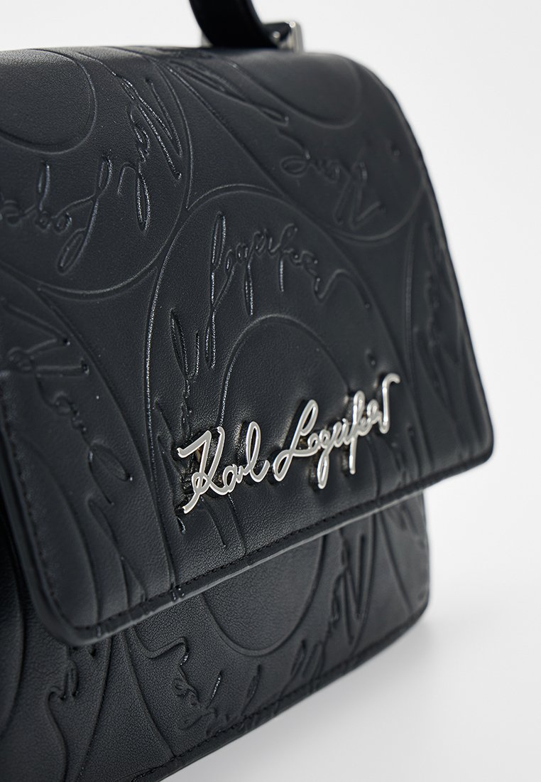 Borsa a mano in pelle nera con texture, decorata con motivi circolari in rilievo e firma argento "Karl Lagerfeld" sulla patta anteriore.