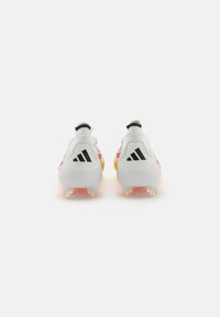 Des crampons de football blancs avec des accents roses, jaunes et noirs. Surface texturée avec une finition lisse, arborant un logo noir sur les côtés et à l'arrière.