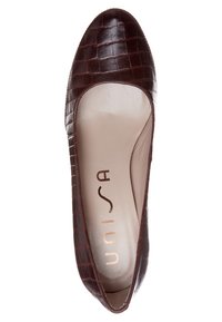 Ballerine en cuir marron à texture crocodile avec bout arrondi et semelle intérieure beige rembourrée, marquée "Unisa" à l'intérieur.