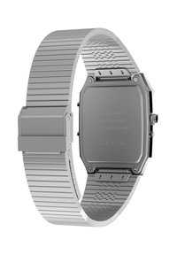 Montre en acier inoxydable argenté avec un boîtier octogonal, un bracelet en maille texturée, et une boucle portant le nom de la marque "TIMEX" gravé.