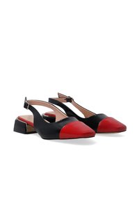 Černé kožené slingback boty s červenou špičkou, nízkým blokovým podpatkem a nastavitelným páskem kolem kotníku. Hladký povrch a elegantní design.