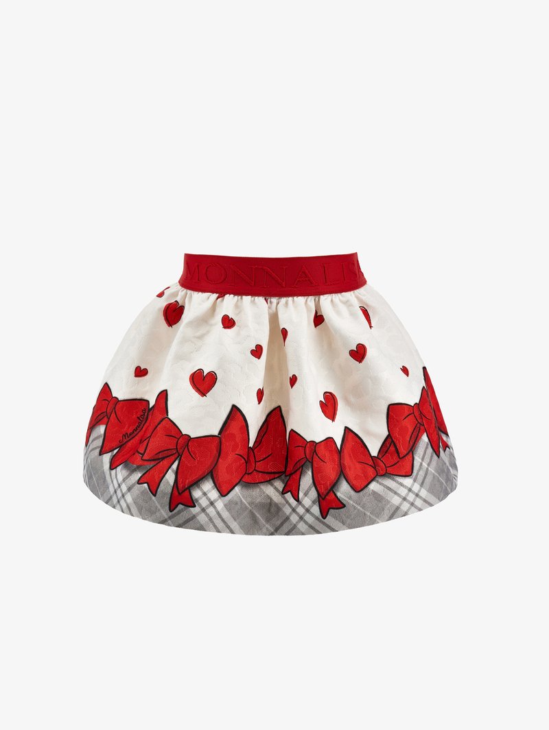 Jupe blanche avec ceinture rouge, décorée de cœurs rouges et de nœuds, avec une bordure à carreaux gris à l'ourlet.