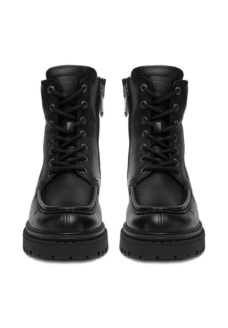 Un paio di stivali neri in pelle con lacci e cerniere laterali, con suole in gomma spessa, visti frontalmente.