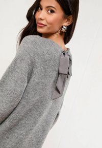 Pulover gri din material moale, cu un detaliu în formă de funda din satin pe spate. Design simplu, cu mâneci lungi și o textură ușoară.