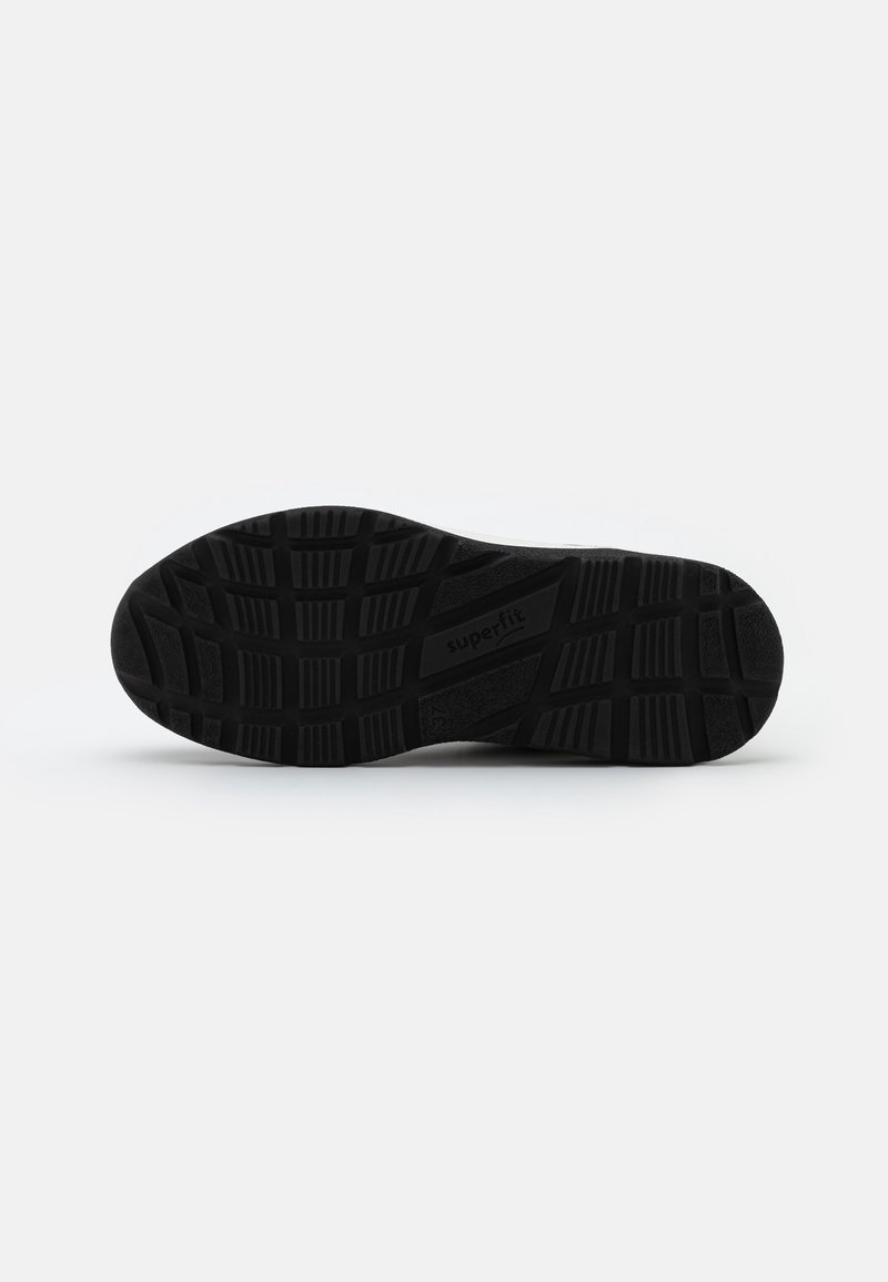 Semelle de chaussure en caoutchouc noir avec motif de bande de roulement texturé, comprenant des rainures et des crêtes pour la traction. Étiquette "superfit" visible sur le côté.