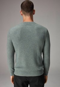 Pullover tricotat gri-albastru cu textură în relief, guler rotund și mâneci lungi. Dispune de un tiv ajustat. Vederea din spate arată un design fără cusături și detalii minime.