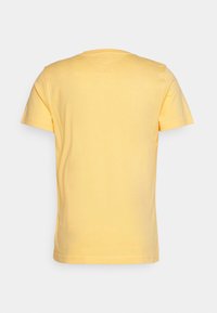 T-shirt amarelo de manga curta em algodão suave com decote redondo. Textura suave e design simples de corte reto, mostrando a vista traseira.