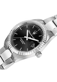 Klocka i rostfritt stål med svart urtavla, silverfärgade visare och datumvisning. Har en texturerad bezel och en länkad armbandsdesign.