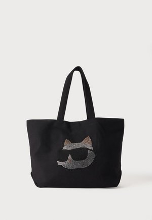 Sort shopper med to håndtag med design af et katteansigt iført solbriller lavet af små metalnitter.
