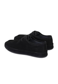 Chaussures en daim noir avec un design à lacets, bout rond et couture contrastante le long de la semelle. Texture douce et profil bas.