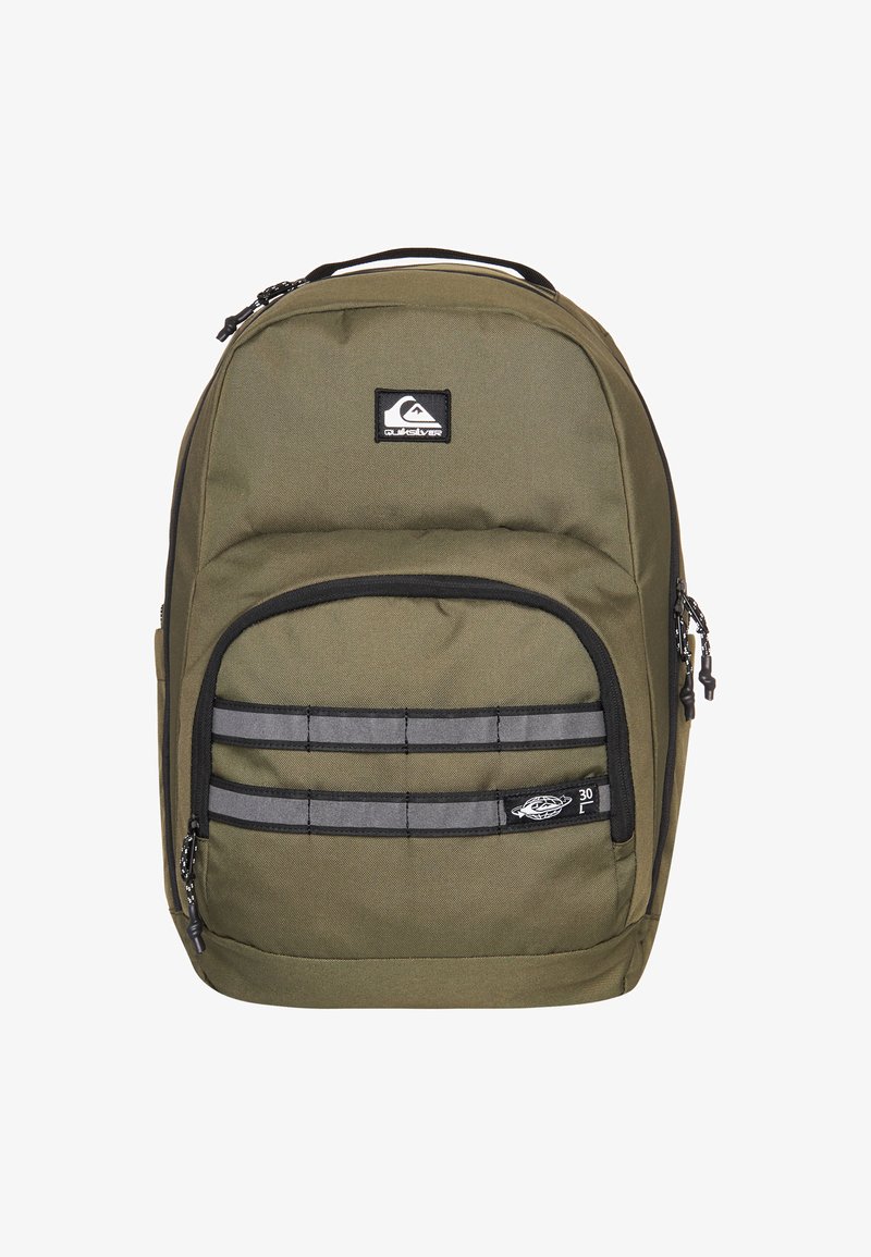 Mochila verde oliva con detalles negros, que presenta un compartimento principal, dos bolsillos frontales y tiras reflectantes para mayor visibilidad.
