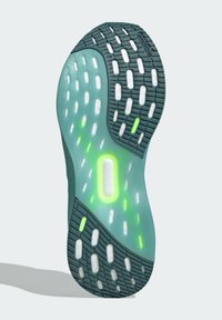 Shoe sole in turquoise with white and green accents. Textured rubber with a patterned tread for grip, featuring a translucent midsole detail.
