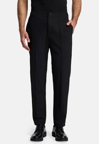 Pantaloni neri plissettati con taglio dritto, dotati di tasche laterali e chiusura con bottone. Realizzati in un tessuto leggero e liscio.
