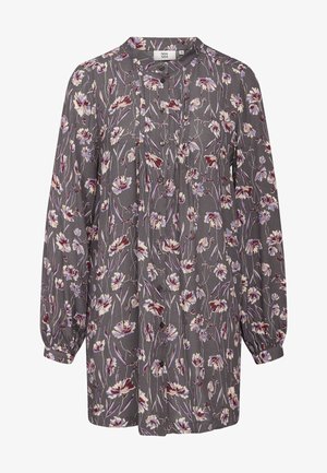 Långärmad blus i grått tyg med blommönster i lila, vitt och rött. Har en knäppning framtill och smockade ärmar.