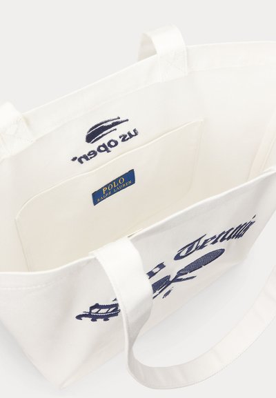 Λευκή τσάντα tote από καμβά με κεντημένο λογότυπο σε ναυτικό μπλε, εσωτερική τσέπη και μπλε ετικέτα "Polo Ralph Lauren" εσωτερικά.