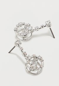 Ασημένια σταγονίδια σκουλαρίκια με στρογγυλές διαφανείς πέτρες, με κυκλικό σύμπλεγμα πολύτιμων λίθων και ευθεία καρφίτσα, σε λευκό φόντο.