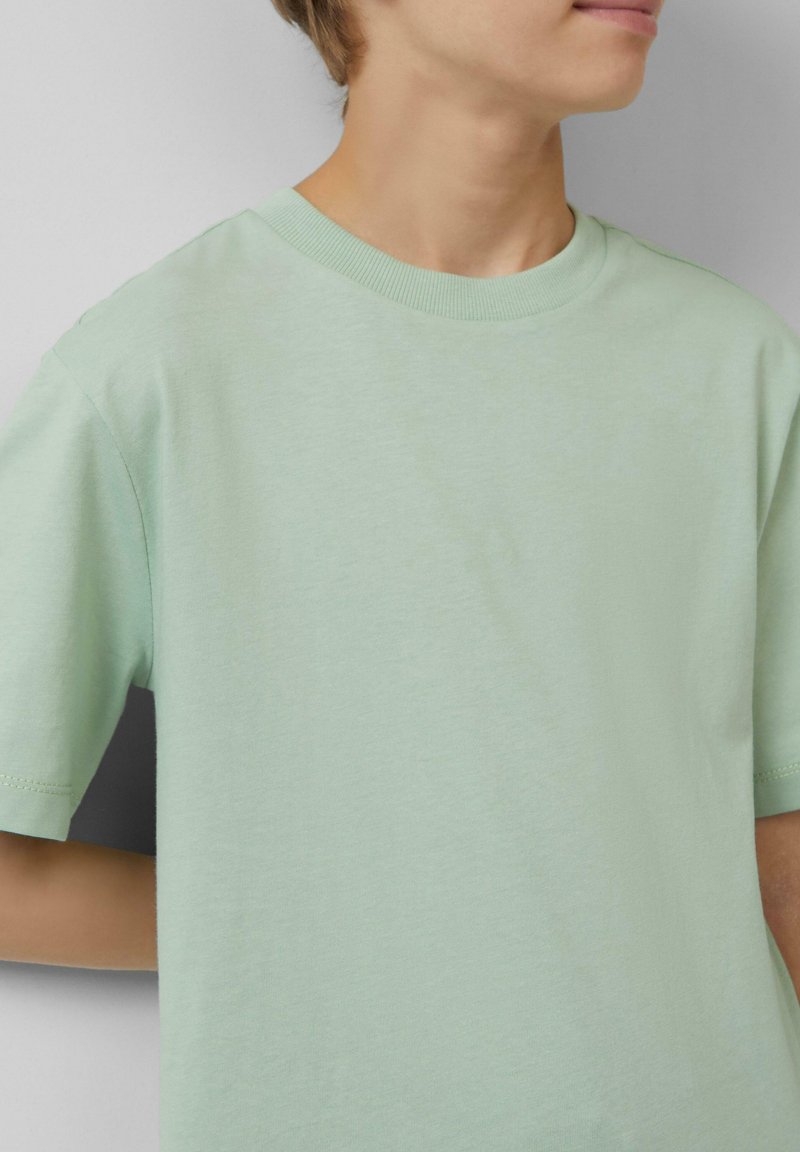 Lichtgroene katoenen t-shirt met korte mouwen, ronde hals en een zachte textuur. Heeft een ontspannende pasvorm en minimale stikdetails.