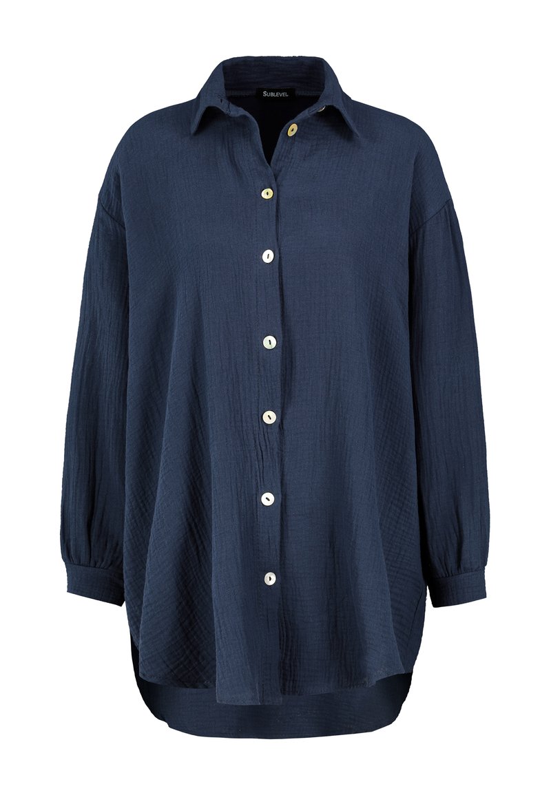 Navy blue button-up shirt made from textured fabric. Features a collar, long sleeves with buttoned cuffs, and contrasting buttons.