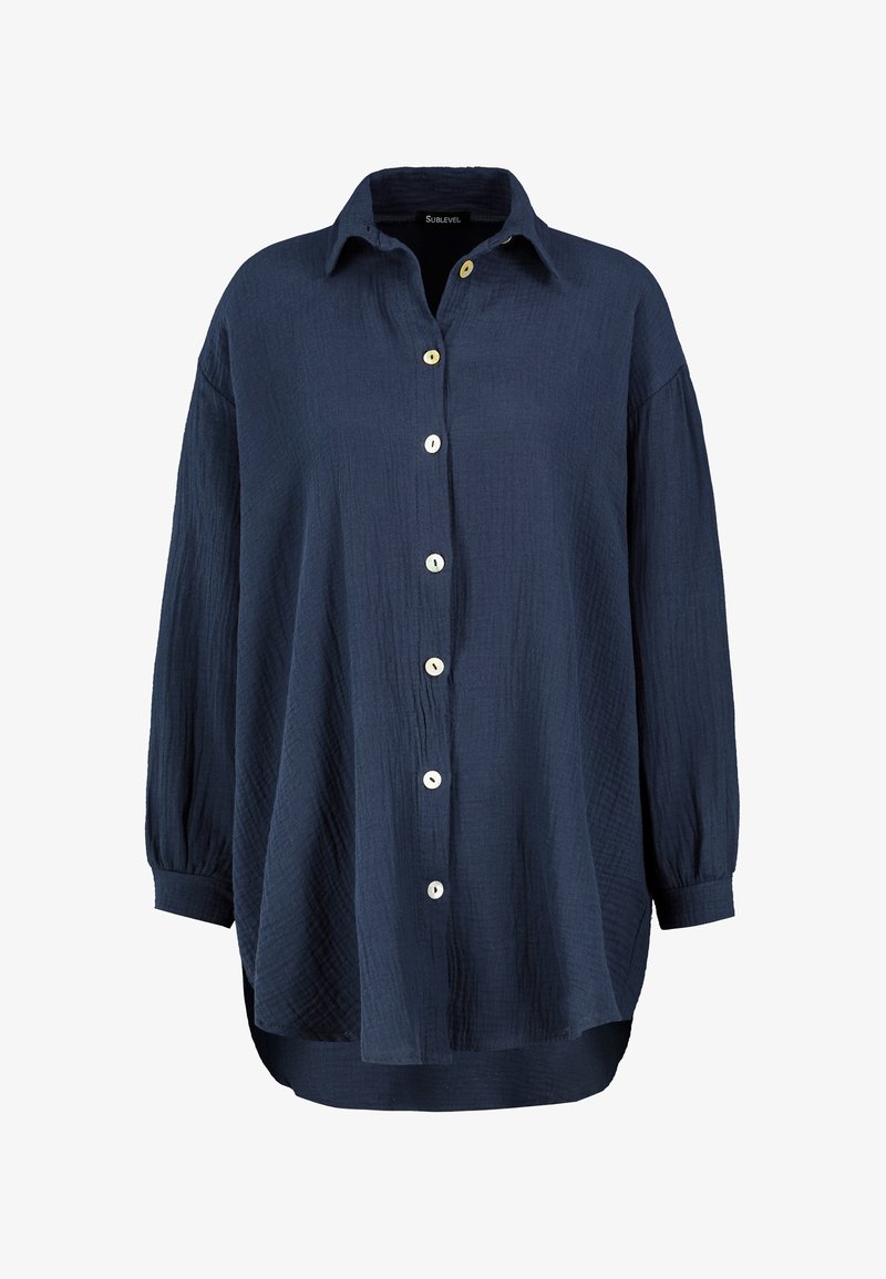 Navy blue button-up shirt made from textured fabric. Features a collar, long sleeves with buttoned cuffs, and contrasting buttons.