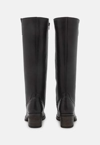 Czarne skórzane kozaki do kolan o gładkiej fakturze, z zamkiem błyskawicznym po boku i drewnianym obcasem na słupku. Prosty i funkcjonalny design.