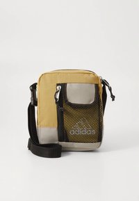 Geantă mică, dreptunghiulară, din material galben și gri, cu un buzunar din plasă și curea neagră. Include un logo pe zona din plasă.