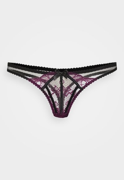 Tanga in pizzo viola e nero, caratterizzato da motivi floreali, texture trasparente e un delicato fiocco in satin sul davanti. Spalline elastiche sottili.