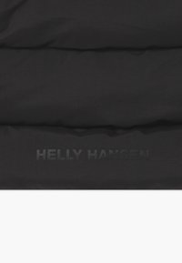 Matière matelassée noire avec une texture à carreaux. Logo en relief "HELLY HANSEN" en bas. Le design est minimaliste, sans motifs ni accents.