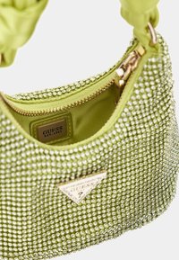 Zielona torebka z ozdobami z kryształków, złotym zamkiem błyskawicznym i satynowym paskiem. Wnętrze wyposażone w naszywkę z logo i gładką podszewkę.