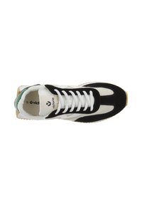 Zapatilla en blanco y negro con parte superior de ante y malla, que presenta un diseño de cordones y una suela exterior de goma texturizada. Acento verde en el talón.