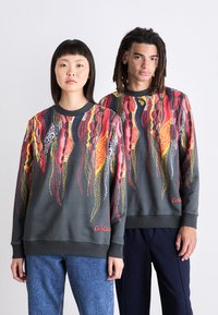 Gray sweatshirts featuring vibrant, abstract patterns in red, yellow, and white. Includes ribbed cuffs and a logo on the front.