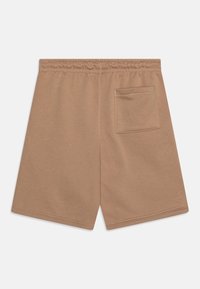 Béžové bavlněné šortky s elastickým pasem. Mají jednu zadní kapsu a hladkou, měkkou texturu. Rovný střih nohavic.
