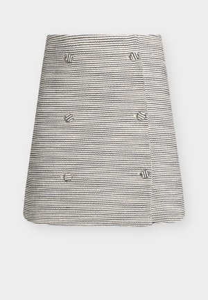 Μικρή μαύρη και λευκή φούστα με οριζόντιες ρίγες και έξι κουμπιά καλυμμένα με ύφασμα, τοποθετημένα σε δύο κάθετες σειρές.