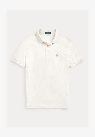 Valkoinen lyhythihainen poolopaita, jossa on kaulus, kaksi nappia ja pieni kirjailtu Polo Ralph Lauren -logo vasemmassa rinnassa.