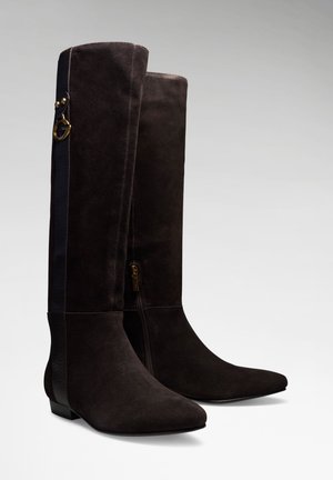 Paire de bottes hautes en daim marron foncé avec talons bas, fermetures éclair latérales et détail décoratif de boucle dorée près du sommet.