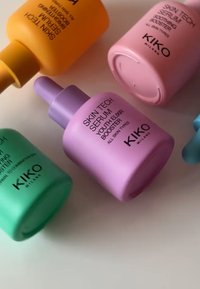 Fyra kosmetikflaskor: gula, gröna, rosa och lila, med pipettlock och släta ytor, märkta med produktnamn och varumärket "KIKO".