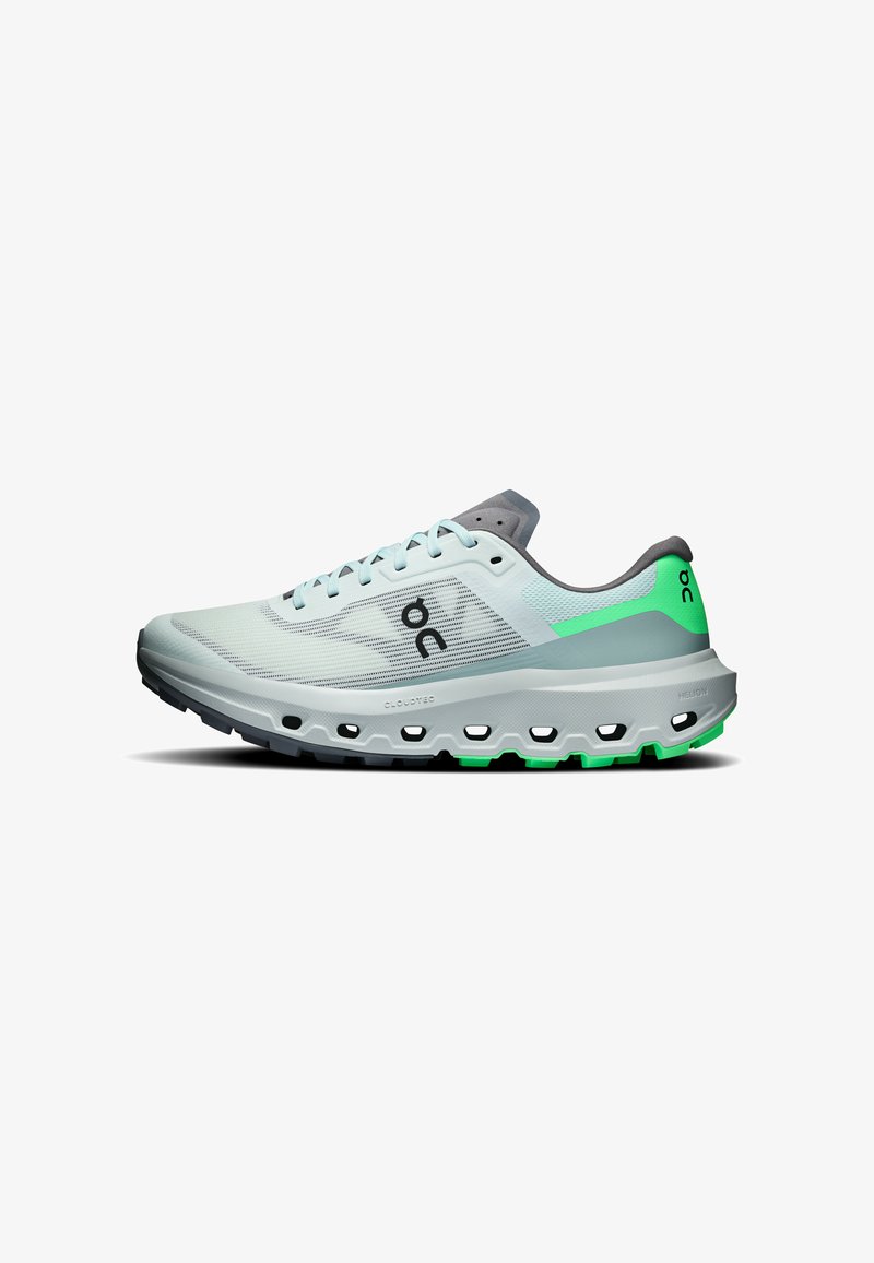 Chaussure de course bleu clair avec des accents verts, semelle rembourrée avec sections creuses, et logo de la marque sur le côté et le talon.
