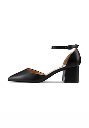 Chaussure à talon haut en cuir noir avec un bout pointu, une sangle de cheville et un talon bloc. Texture lisse et design minimaliste, avec un intérieur nude.