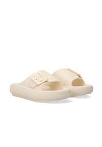 Beige gummislide sandaler med en justerbar rem med en rektangulær spænde, struktureret overdel og rillede såler for bedre greb.
